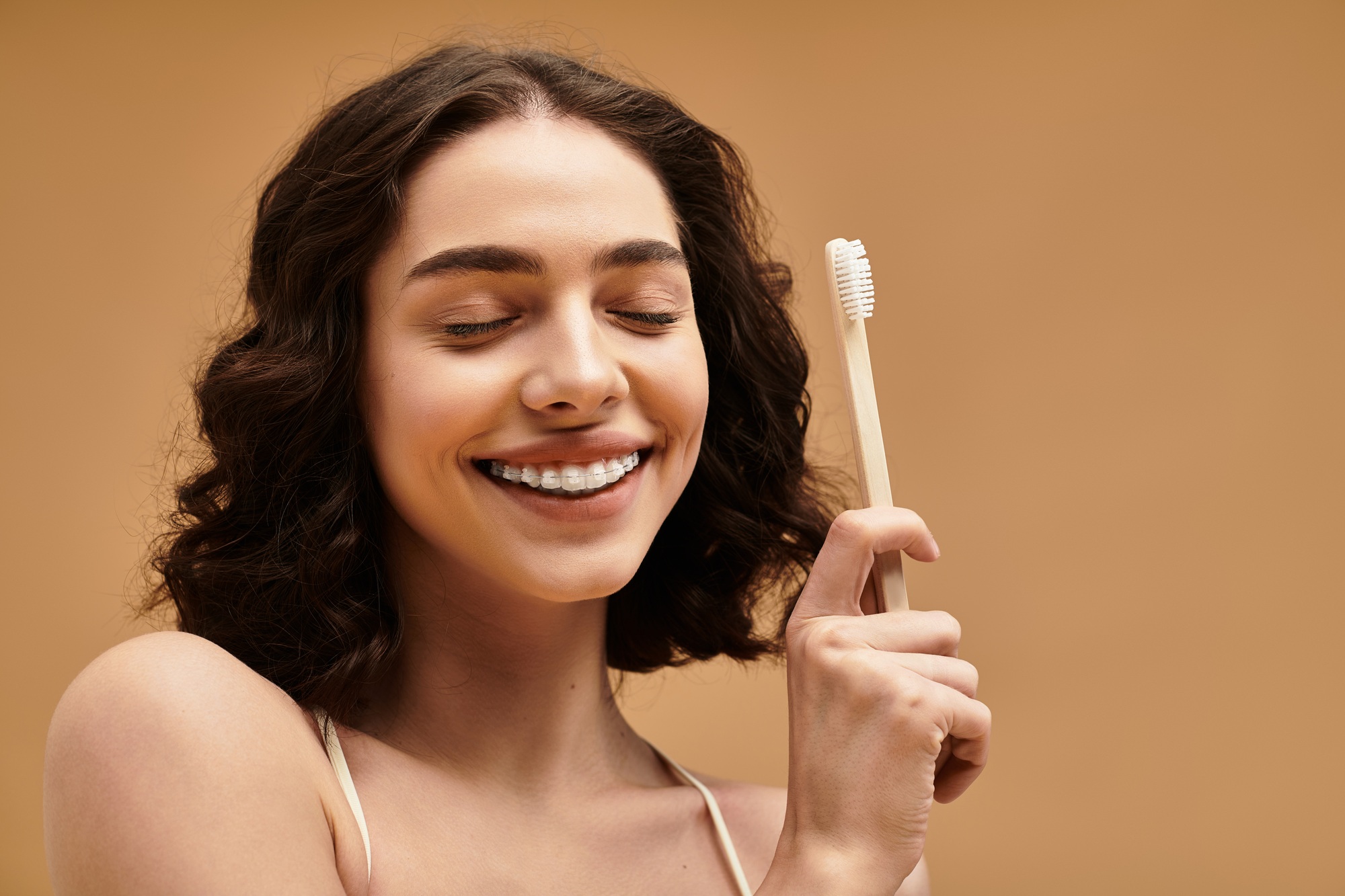 Bright smile of a young woman with toothbrush in hand