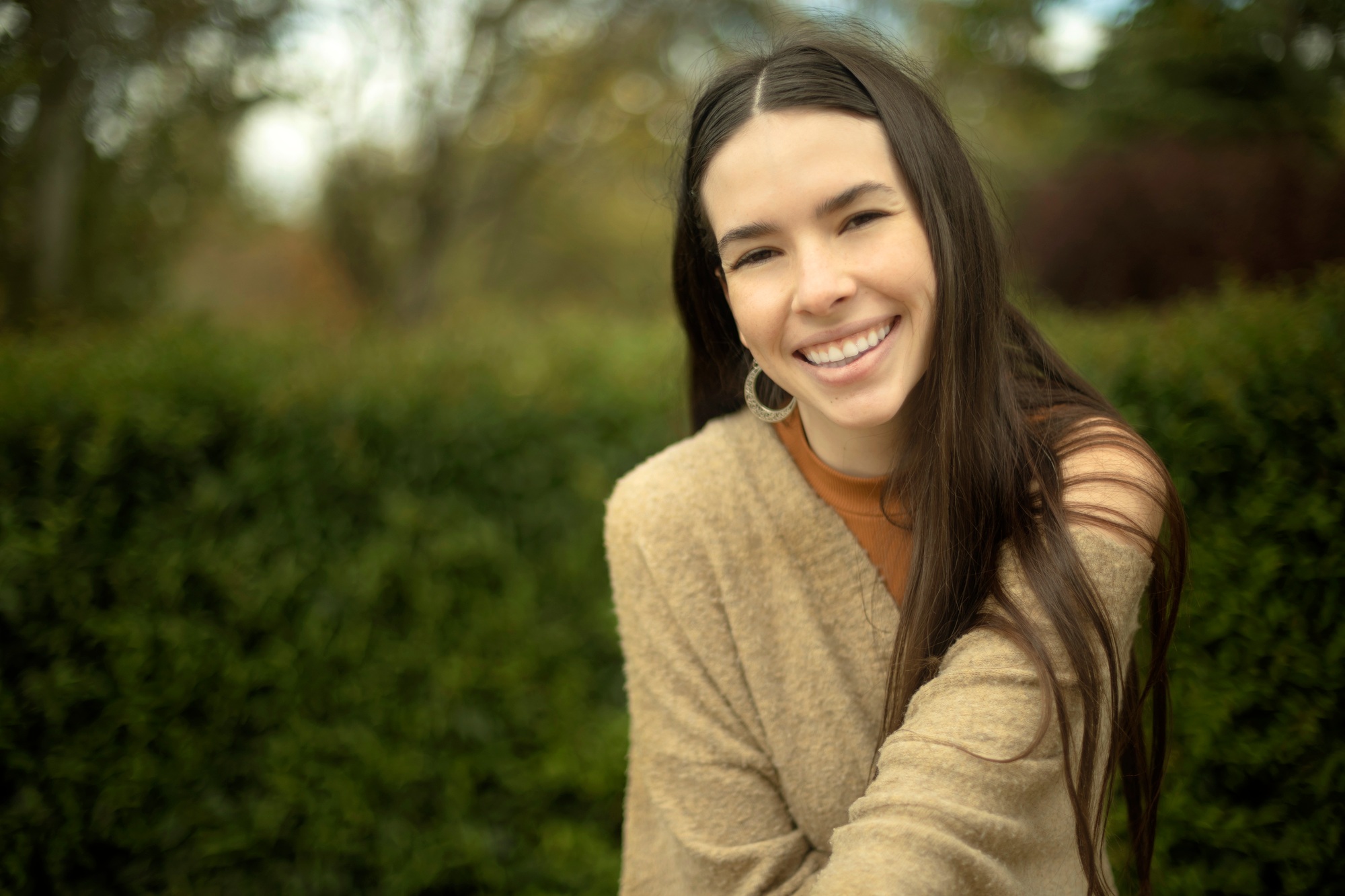 Outdoor portrait of young Caucasian model woman with natural beauty perfect smile looking at camera